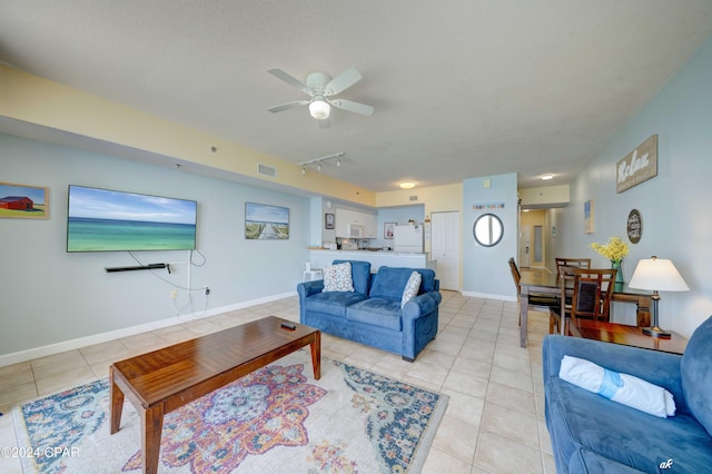living room with visible vents, baseboards, a ceiling fan, and light tile patterned flooring
