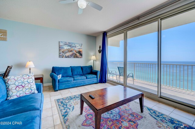 tiled living room featuring a water view and ceiling fan