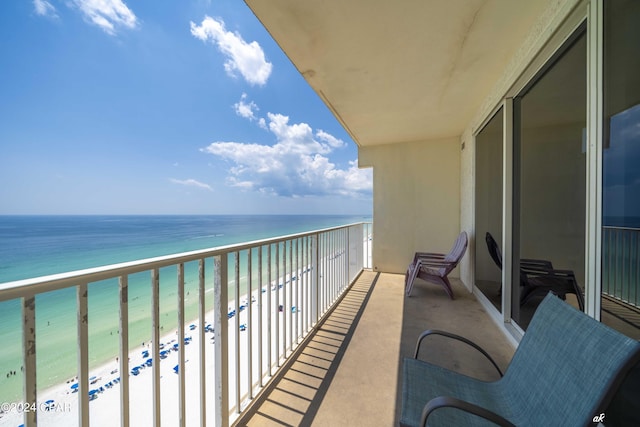 balcony featuring a view of the beach and a water view