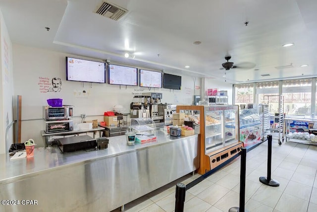 kitchen with ceiling fan, tile patterned flooring, a wall of windows, visible vents, and stainless steel countertops