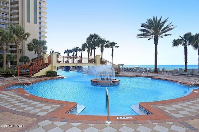 view of swimming pool featuring a water view and pool water feature