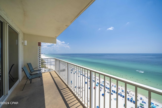 balcony with a water view and a beach view
