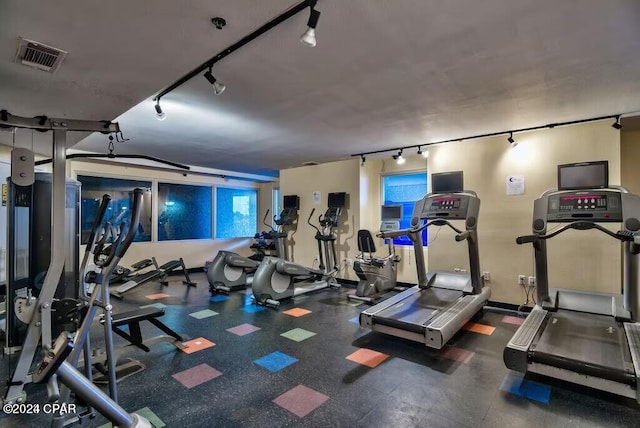 exercise room with track lighting and visible vents