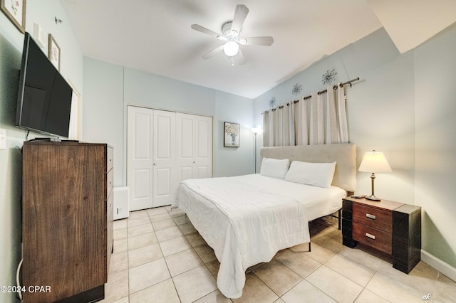 bedroom featuring a closet, ceiling fan, light tile patterned flooring, and baseboards