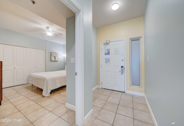 foyer with light tile patterned floors, baseboards, and a ceiling fan