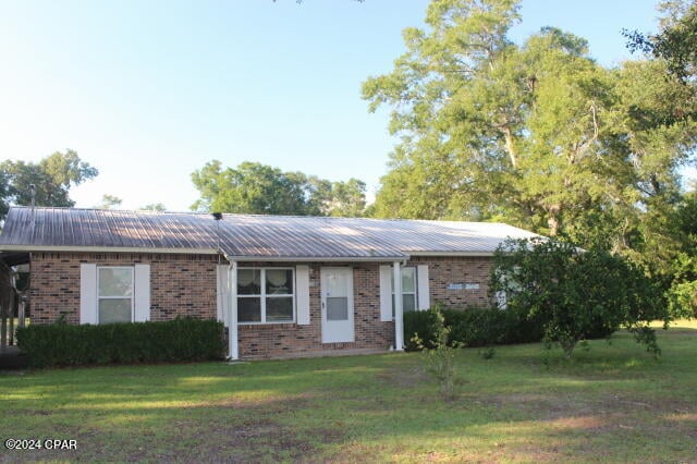 ranch-style home featuring a front lawn