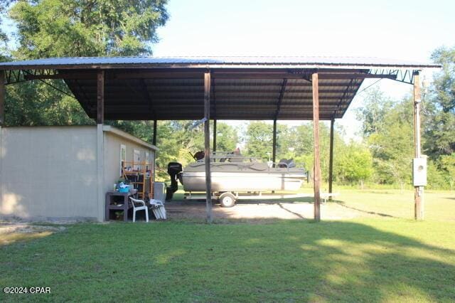 view of parking / parking lot featuring a carport and a yard