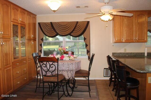 dining area with ceiling fan and a textured ceiling