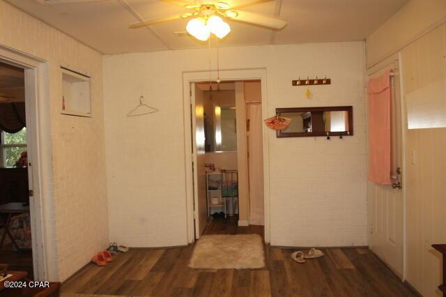 6562 Messer Rd, Grand Ridge, FL 32442 - hallway with wood finished floors and brick wall