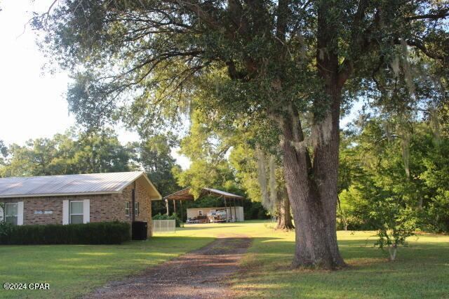 exterior space featuring a carport and a lawn