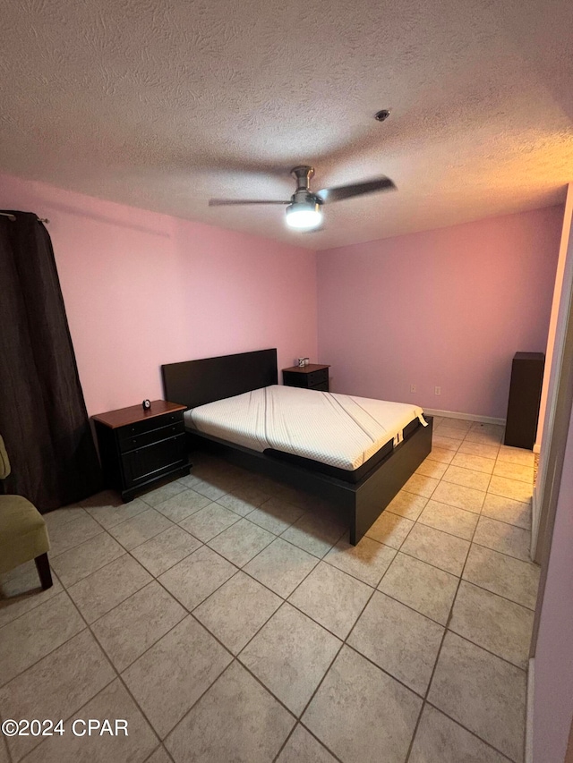 unfurnished bedroom featuring light tile patterned floors, a textured ceiling, and ceiling fan