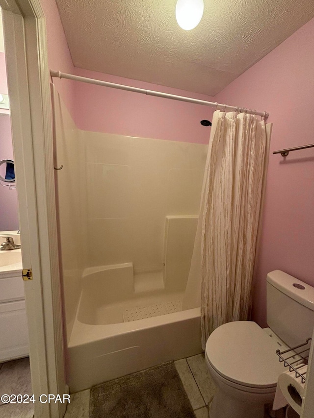 full bathroom featuring a textured ceiling, vanity, toilet, and shower / bath combination with curtain