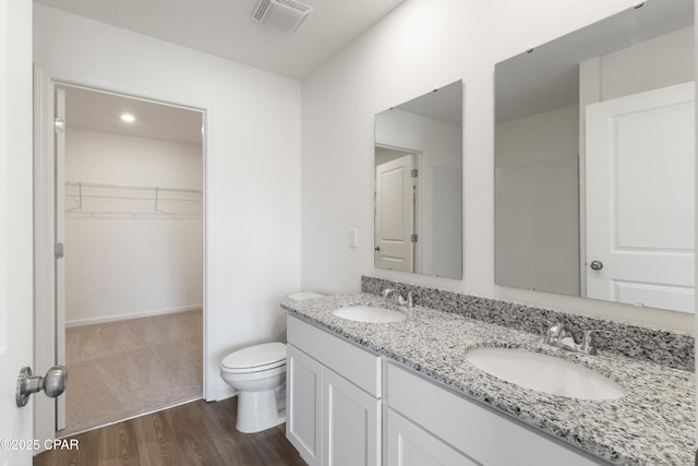 bathroom featuring vanity, hardwood / wood-style floors, and toilet