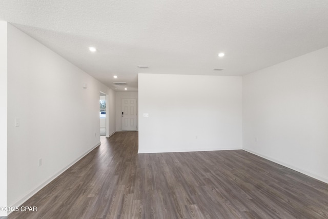 unfurnished room featuring dark hardwood / wood-style flooring and a textured ceiling