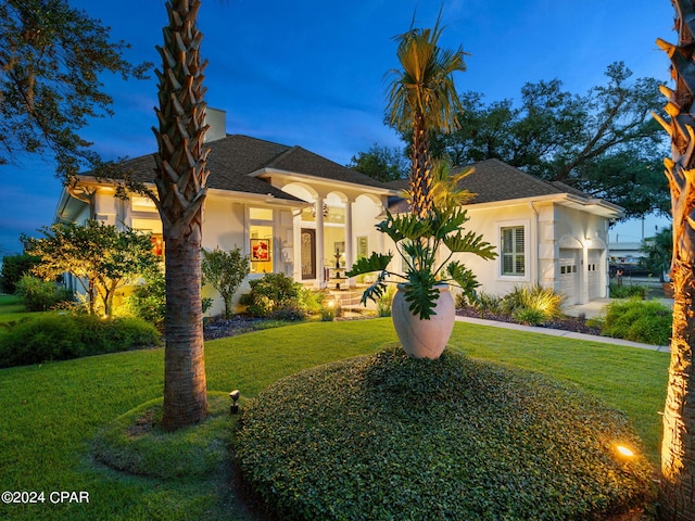 mediterranean / spanish house featuring a garage and a front lawn