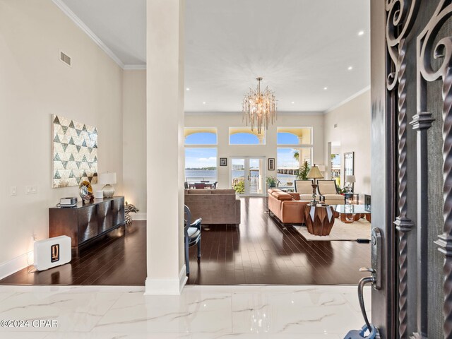 interior space with crown molding, wood-type flooring, and a notable chandelier