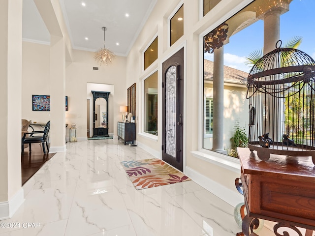 entryway with marble finish floor, baseboards, a chandelier, and crown molding