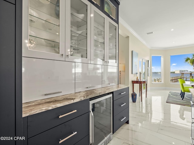 bar with light stone countertops, light tile patterned flooring, ornamental molding, and beverage cooler