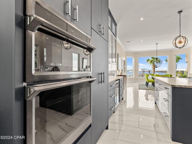 kitchen with ornamental molding, double oven, gray cabinetry, light tile patterned flooring, and hanging light fixtures