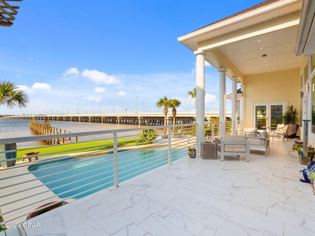 view of pool featuring a patio, an outdoor hangout area, and a water view