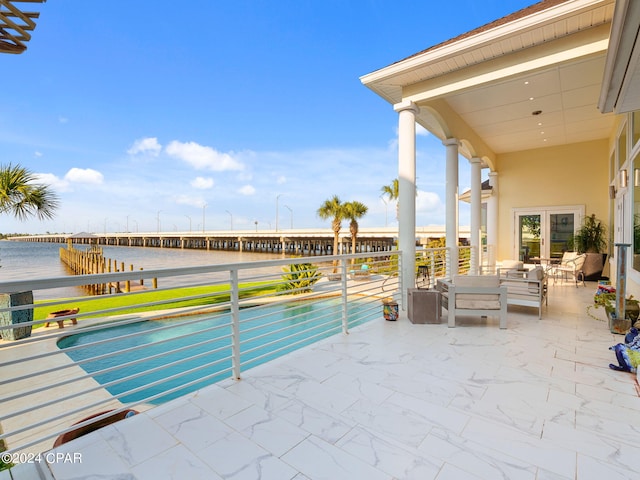 view of pool featuring a water view, an outdoor hangout area, and a patio