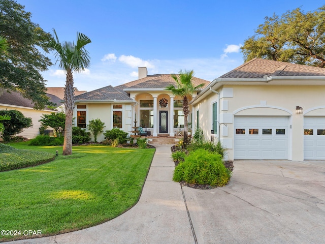 mediterranean / spanish house with a garage and a front lawn