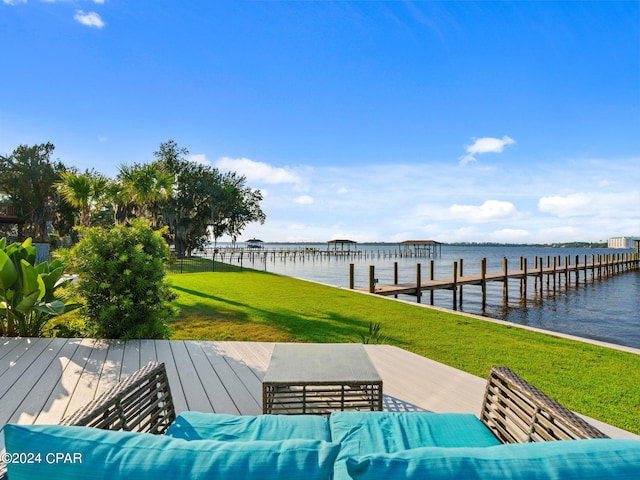 exterior space featuring a dock, outdoor lounge area, and a water view