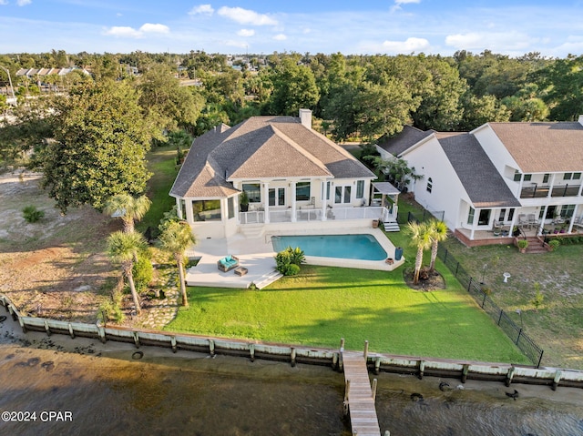 back of house with a chimney, a lawn, a patio area, a fenced backyard, and an outdoor pool