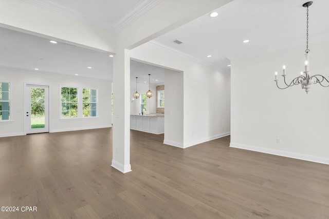 unfurnished room with ornamental molding, wood-type flooring, and a chandelier