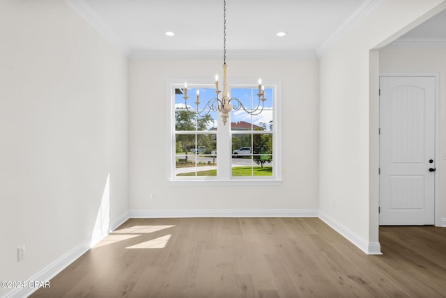 unfurnished dining area with light wood-type flooring, ornamental molding, and a notable chandelier