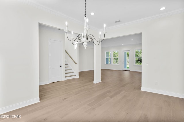 unfurnished dining area featuring light wood-type flooring, crown molding, and a chandelier