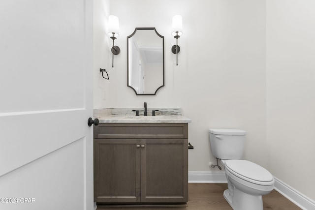 bathroom featuring wood-type flooring, vanity, and toilet