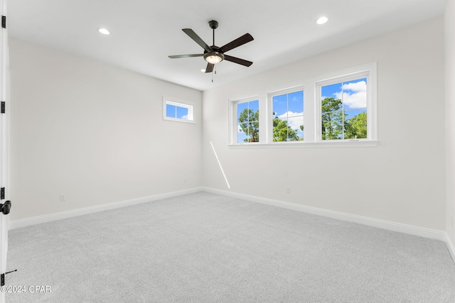 spare room featuring light carpet and ceiling fan