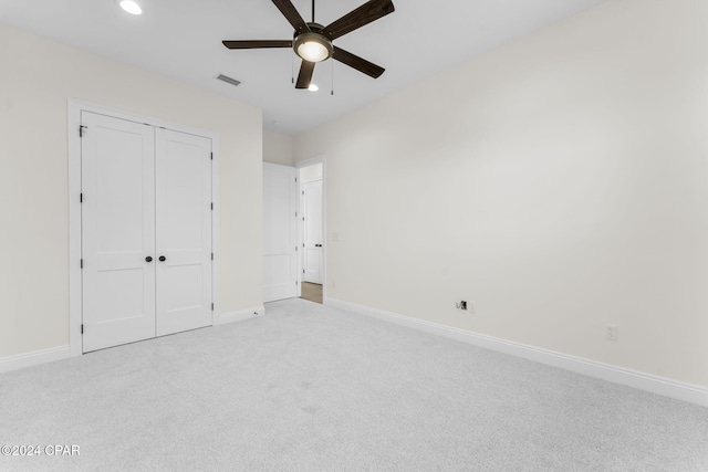 unfurnished bedroom with light carpet, a closet, and ceiling fan