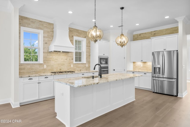 kitchen featuring white cabinetry, appliances with stainless steel finishes, custom range hood, and sink