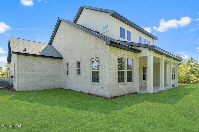 back of property with a lawn and central AC