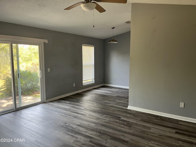 unfurnished room featuring a ceiling fan, dark wood finished floors, a textured ceiling, and baseboards