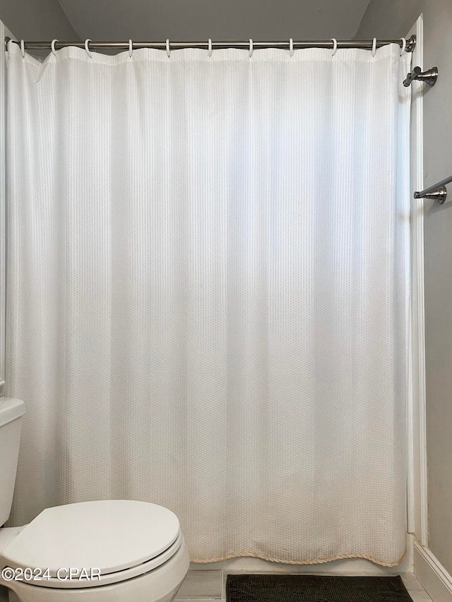 bathroom with toilet and tile patterned floors