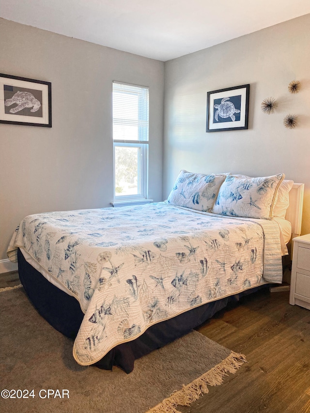 bedroom with dark hardwood / wood-style floors