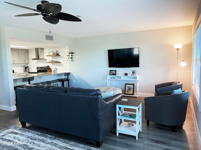 living room featuring dark wood-type flooring and ceiling fan