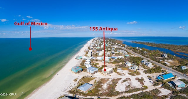 aerial view with a water view and a beach view