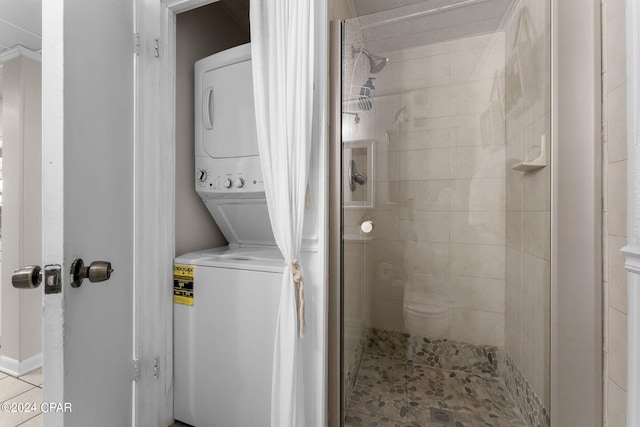 bathroom featuring stacked washer and dryer and a stall shower