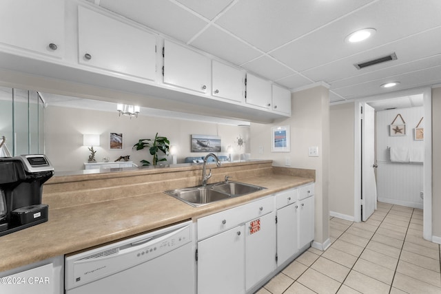 kitchen with white dishwasher, white cabinetry, light countertops, and a sink