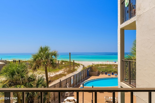 view of pool featuring a water view, a fenced in pool, and a view of the beach