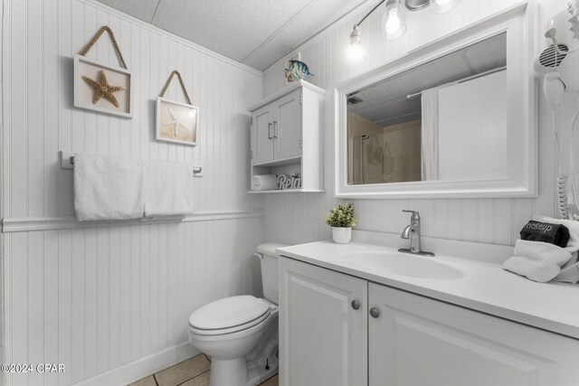 bathroom featuring tile patterned flooring, a shower, toilet, and vanity