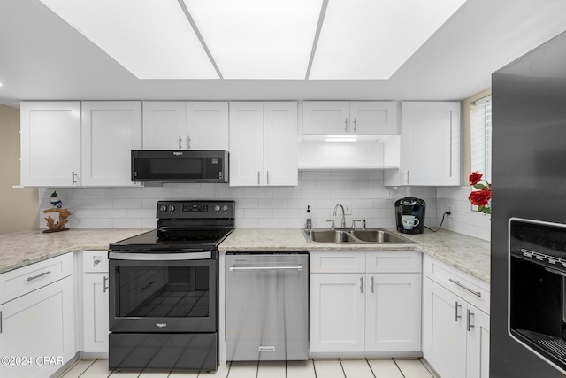 kitchen featuring black appliances, white cabinetry, and decorative backsplash