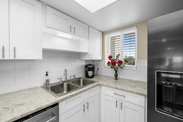 kitchen featuring dishwasher, a sink, refrigerator with ice dispenser, and white cabinets