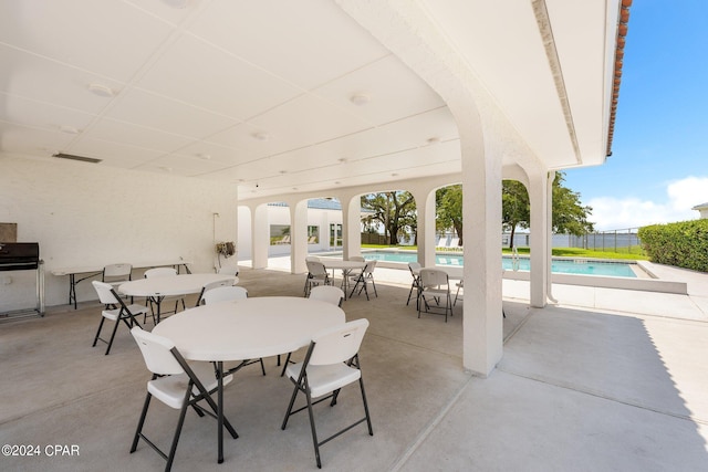 view of patio / terrace featuring visible vents, fence, a fenced in pool, and outdoor dining space