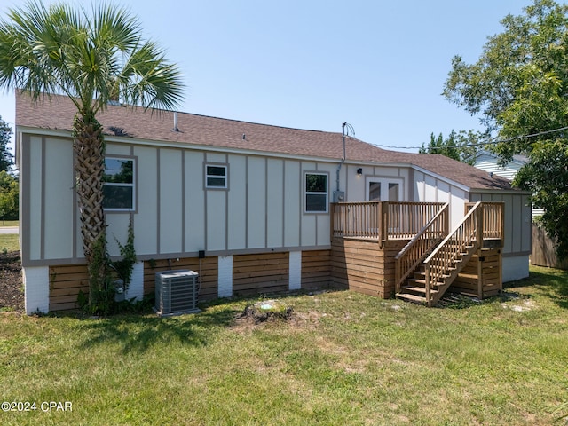 back of property with a lawn, a deck, and central air condition unit