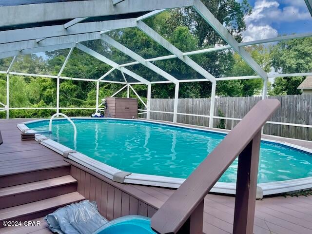 view of swimming pool featuring a lanai and a wooden deck